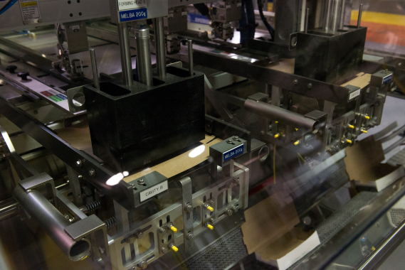 A close-up of the Trayfecta carton forming machine shows cavities being formed in the cartons to make just the right amount of space for the packaged product.