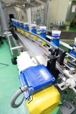An SEW-Eurodvive motor powers a conveyor moving bottles from the heat-shrink tunnel.