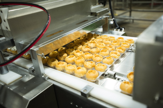  After being packed into the plastic clamshell tray bottoms by the ABB pick-and-place robots, the freshly made rolls are pierced from the top and filled with whipped cream just prior to lidding.